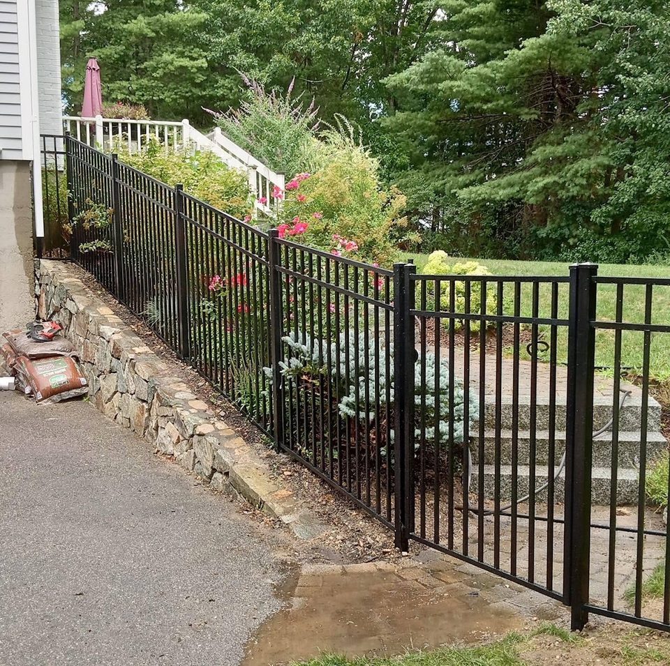 Black aluminum fence running beside a garden path