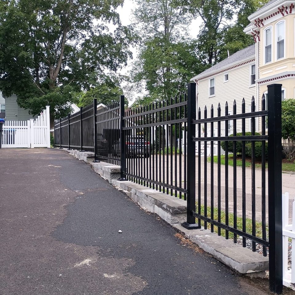 Black ornamental aluminum fence along a driveway frontage