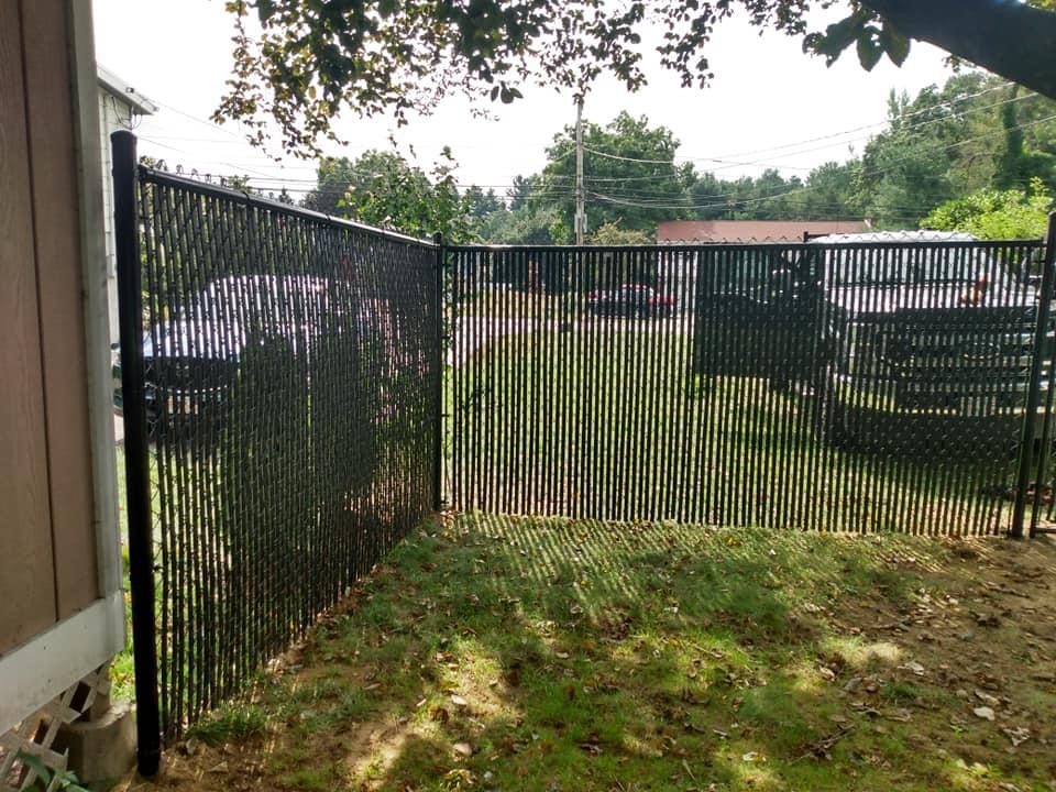 Black chain link fence following a gently sloping lawn
