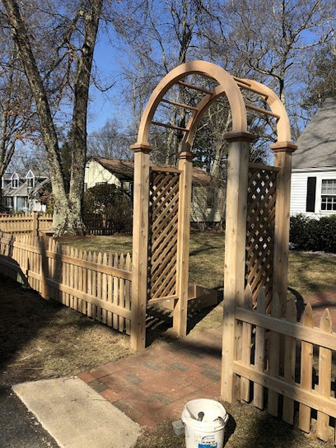 Cedar arbor gate forming a garden entrance with lattice sides