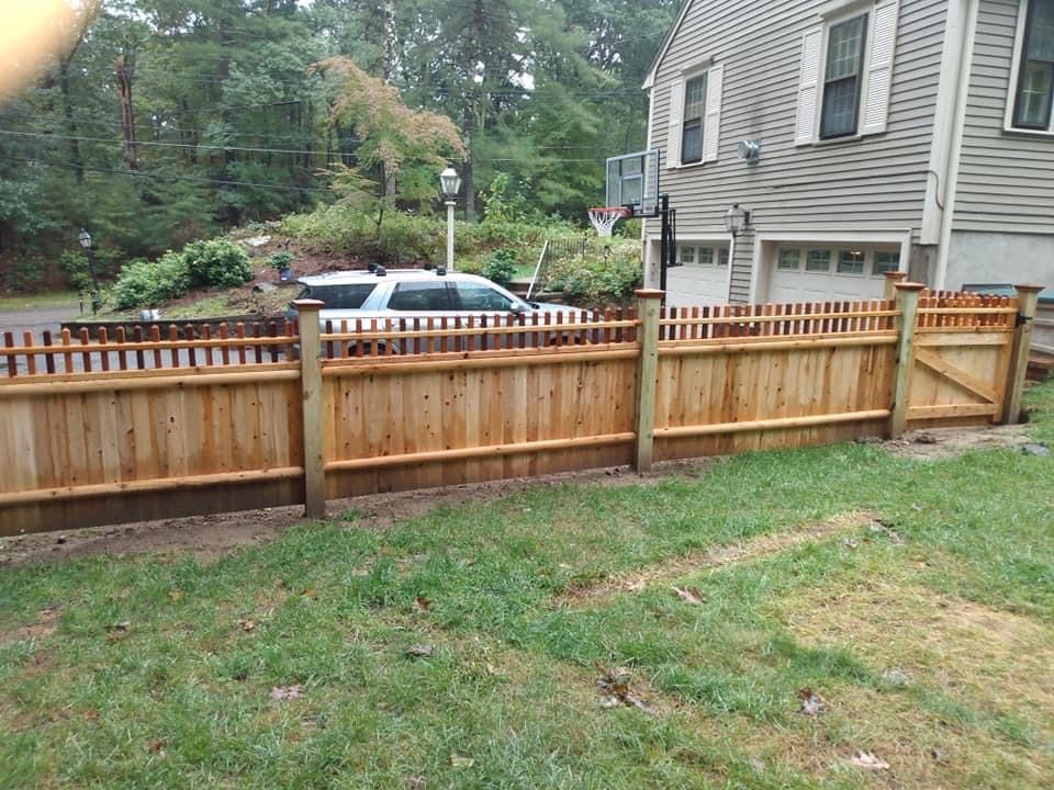 Cedar picket fence across the frontage of a two-storey home