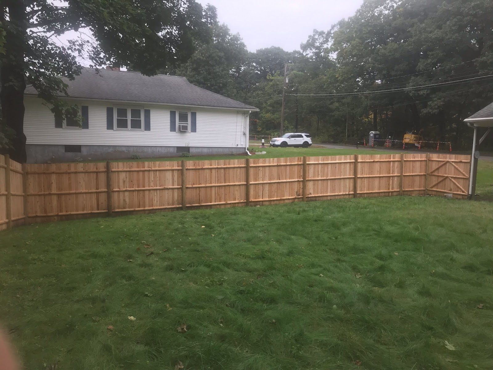 Cedar privacy fence enclosing a back yard behind a family home