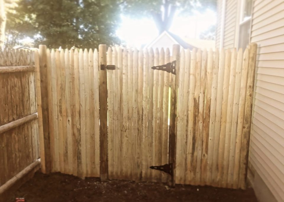 Close view of a cedar privacy gate and its latch hardware