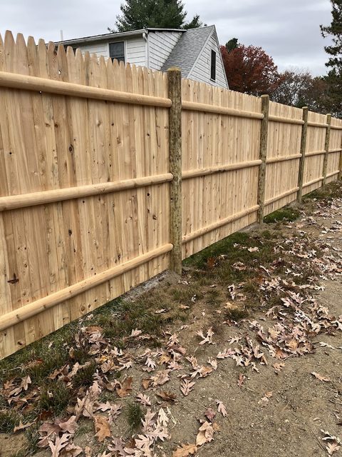 Cedar stockade fence enclosing an autumn back yard