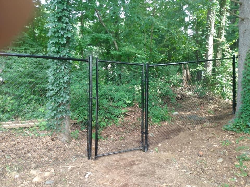 Tall chain link enclosure protecting a vegetable garden