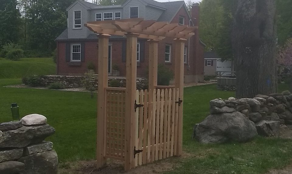 Timber pergola gate marking the entrance to a rear garden