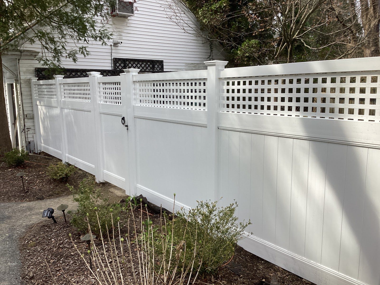 White vinyl privacy fence with lattice top and matching walk gate