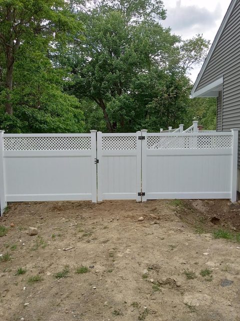 White vinyl double drive gate across a residential driveway