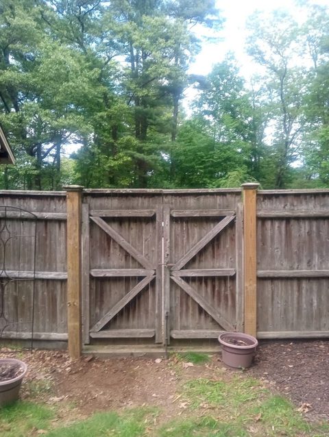 Wooden fence gate with an X-brace and heavy strap hinges